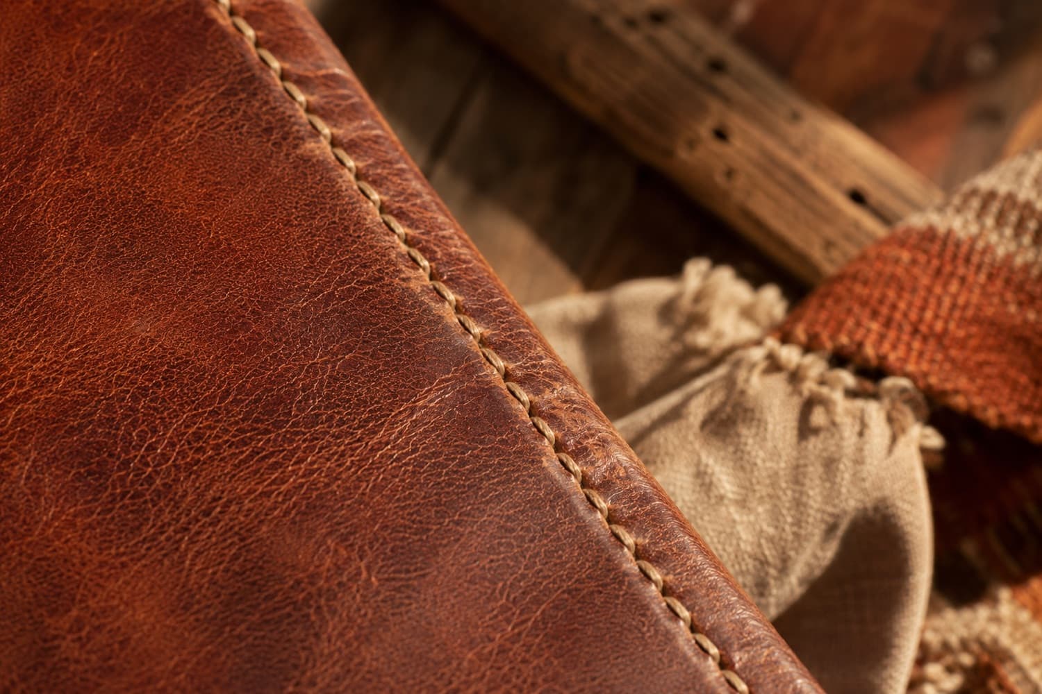 Macro detail of full-grain leather grain and a line of saddle stitching